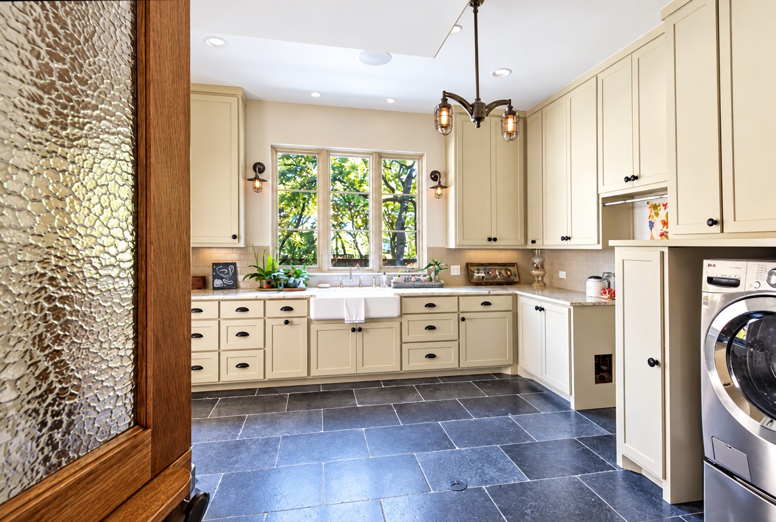 Laundry room with white cabinetry and blue tile floor