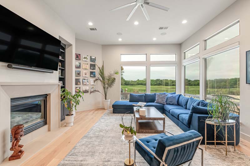 Living room with blue sectional and wide views outdoors