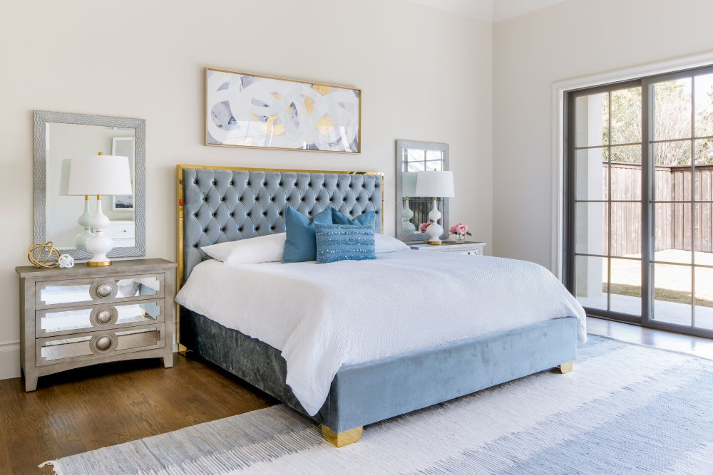 Bedroom with tufted blue headboard and garden doors