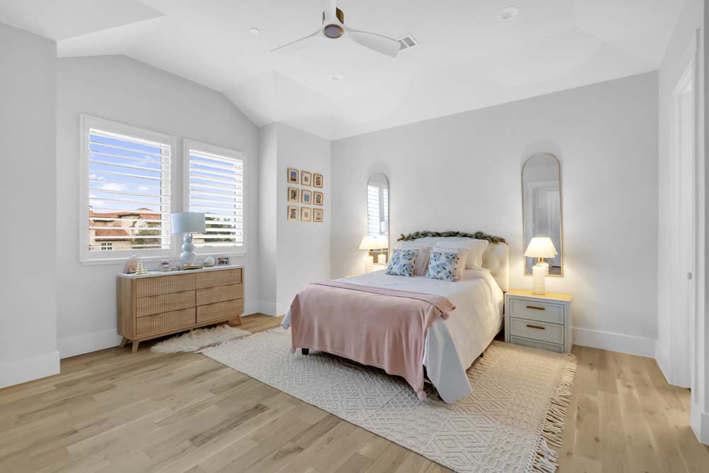 Bedroom with wood dresser and pale pink bedding