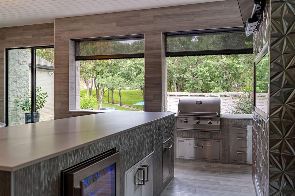 Outdoor kitchen with grill and garden view