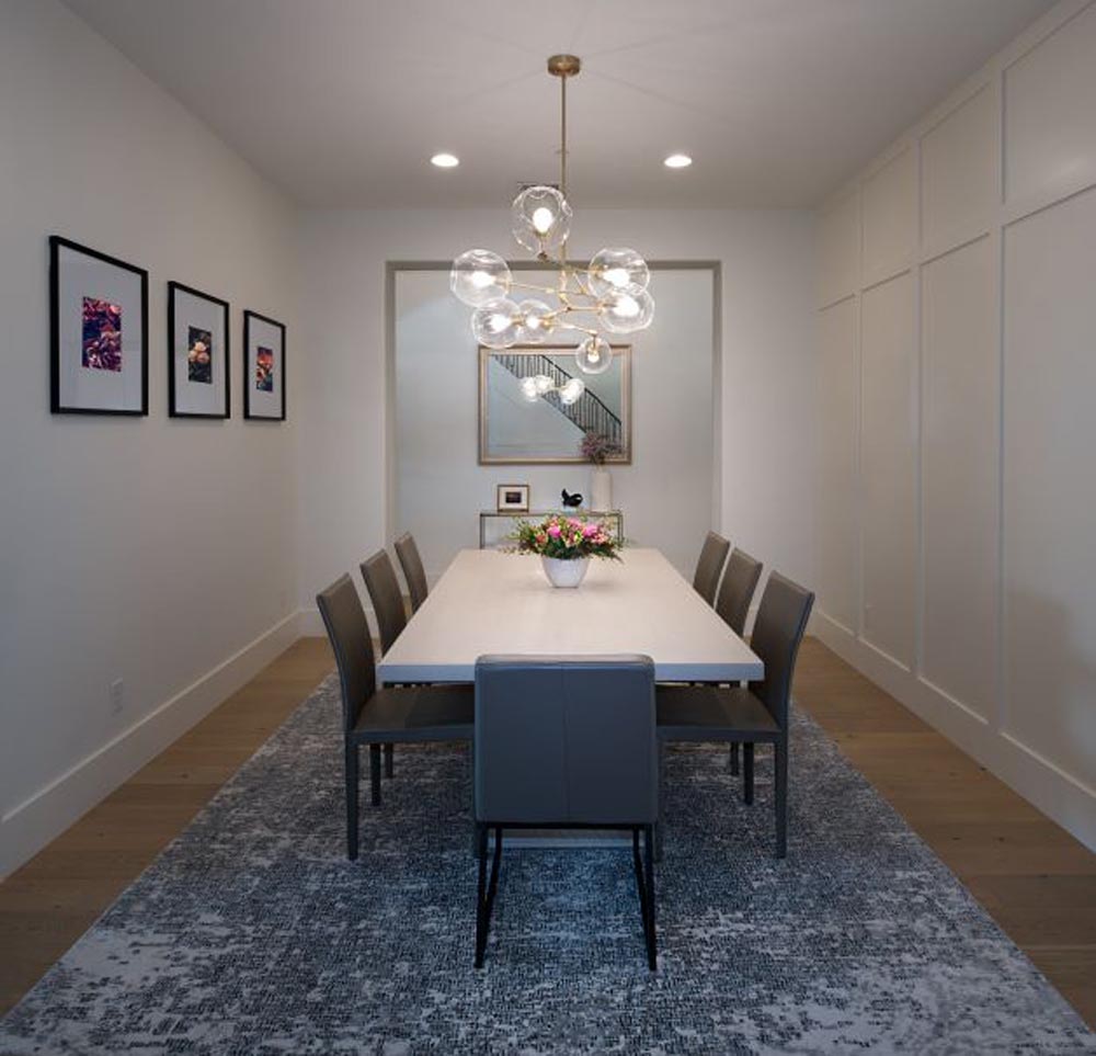 Formal dining room with chandelier and paneled walls