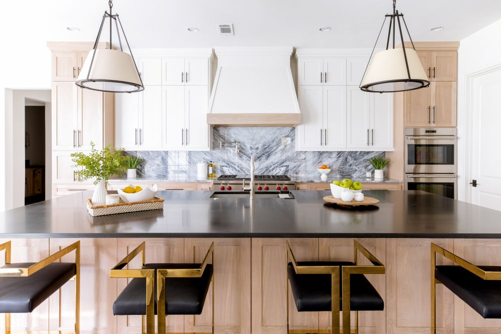 Kitchen island facing white cabinets and marble backsplash